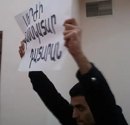Opposition Activist Protests in Court, Holds Sign Implying Court is Doing President's Bidding
